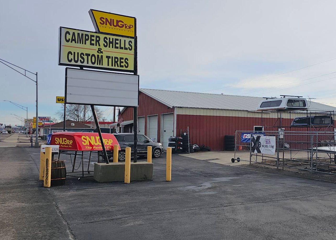 The Custom Tire lot on Chinden: red building, SnugTop sign, shells on racks, used tires